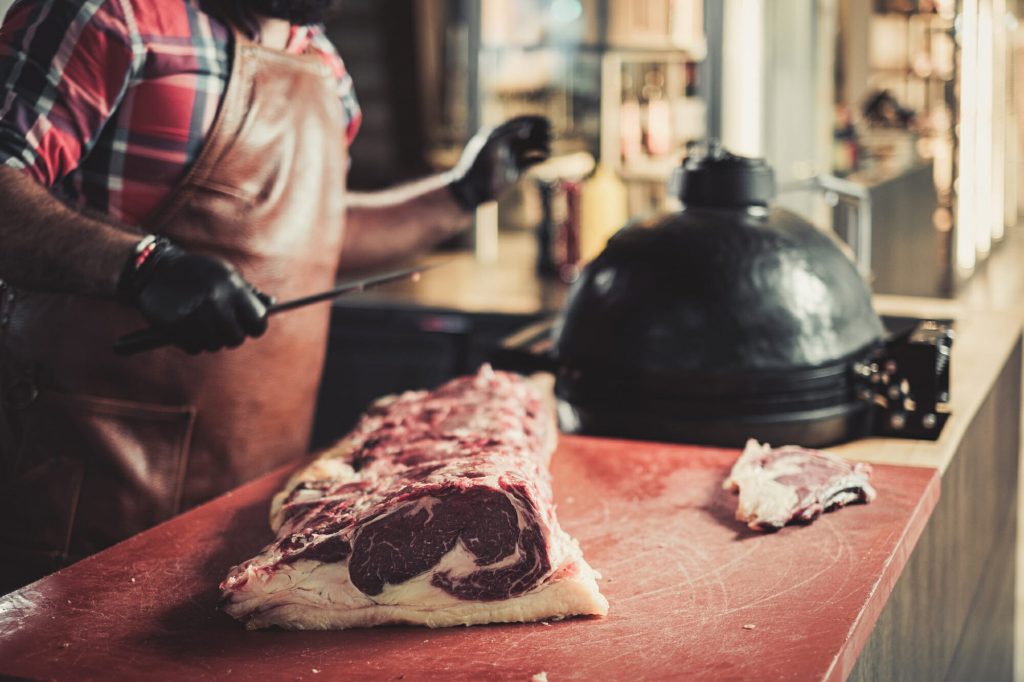 Chef cutting beef steakes in a restaurant
